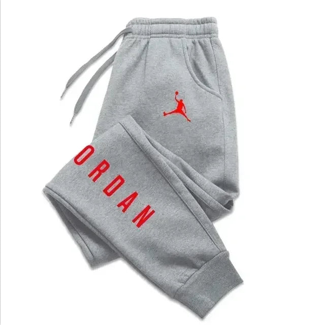 Men’s casual sweatpants in grey with red Jordan logo and drawstring, perfect for comfort and style.