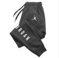 Men’s casual sweatpants in black with white Jordan logo and vertical branding, featuring a drawstring waist and side pockets for comfort and style.