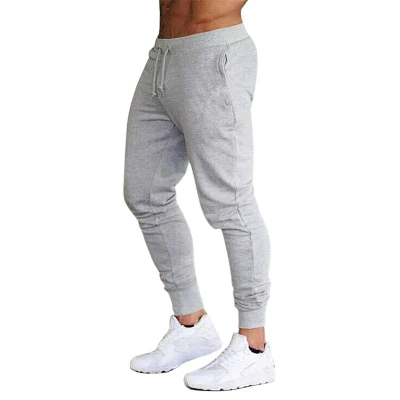 Men’s Sports Jogger Pants in gray, perfect for athletic wear and casual outings, paired with white sneakers.