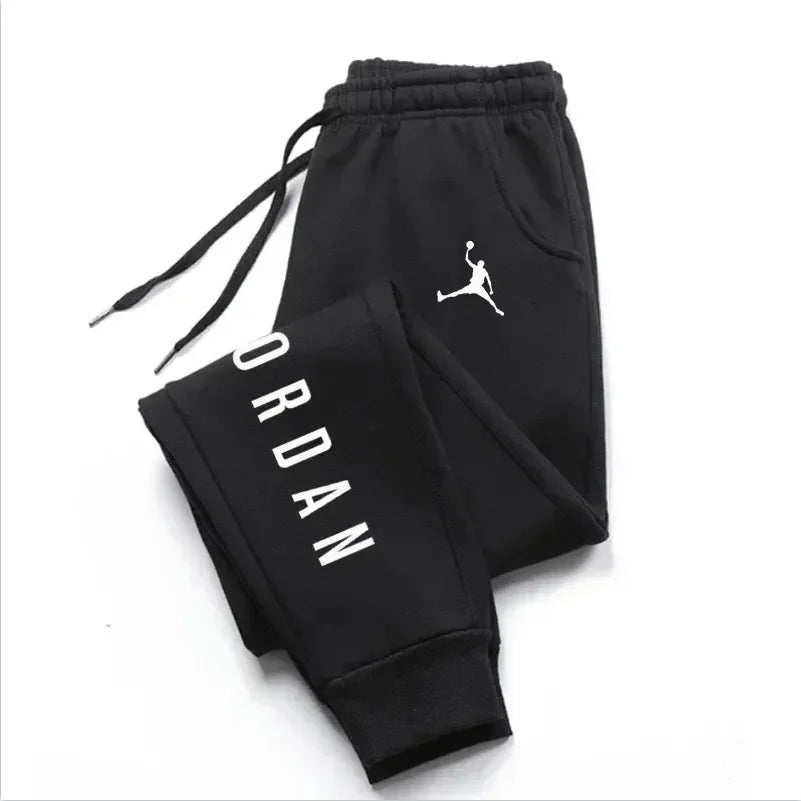 Men’s casual sweatpants in black with white Jordan logo and vertical leg design, featuring drawstring waist for comfort and sporty style.