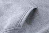 Men’s hooded sweatshirt in gray cotton fabric with stitched pocket opening, highlighting craftsmanship, comfort, and casual streetwear appeal.