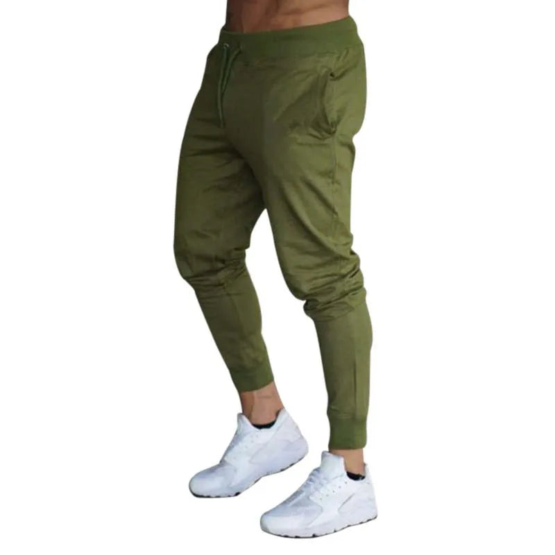 Men’s Sports Jogger Pants in olive green with side pockets, paired with white athletic shoes.