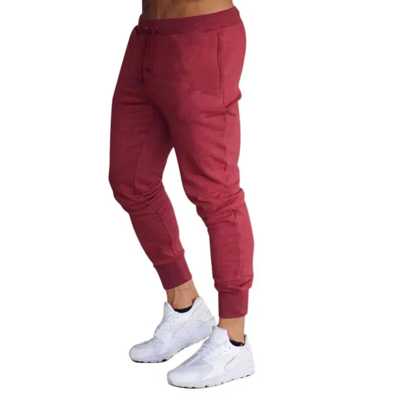 Men’s Sports Jogger Pants in maroon, featuring a modern athletic fit and paired with white athletic shoes.